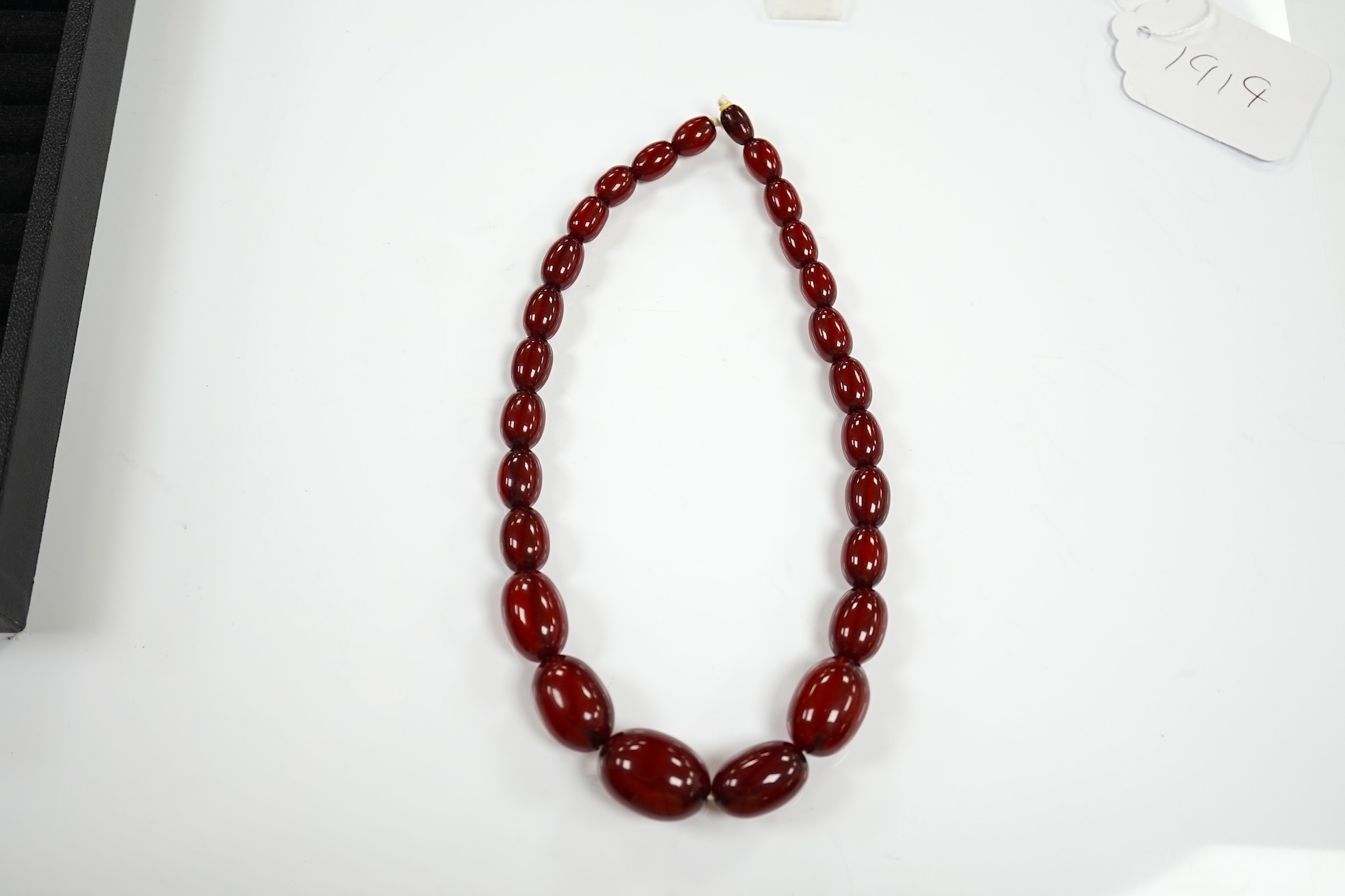 A single strand graduated oval simulated cherry amber bead necklace, 38cm, gross weight 41 grams. Condition - poor to fair